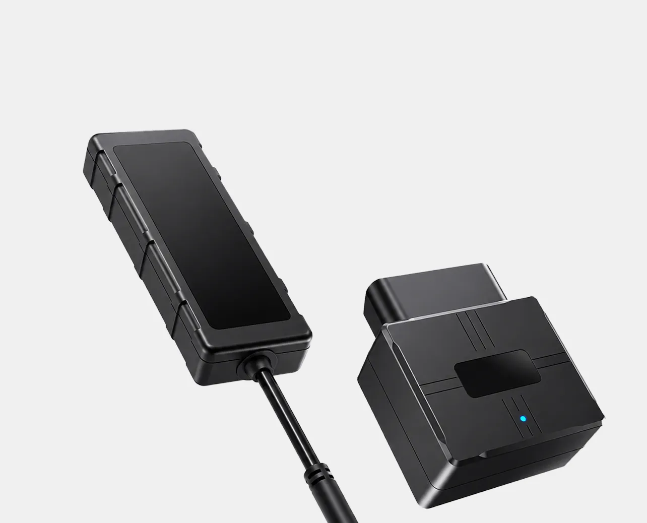 Schwarze Fahrzeugortungsgeräte mit Kabel und Stecker auf grauem Hintergrund.