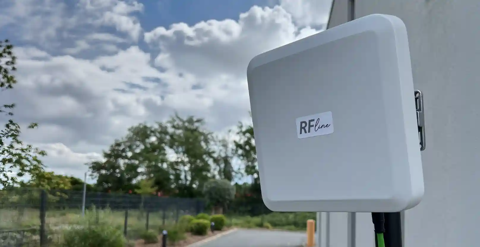 Weiße rechteckige Außenantenne mit Aufschrift RFline an einer Gebäudewand montiert.