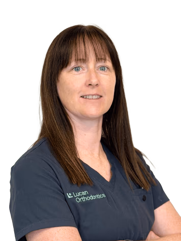 Portrait of a woman with long brown hair wearing a navy blue Lucan Orthodontics uniform.