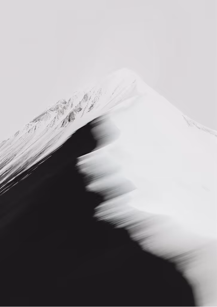 Abstract image of a snow-covered mountain peak with blurred black and white streaks creating a dynamic effect.
