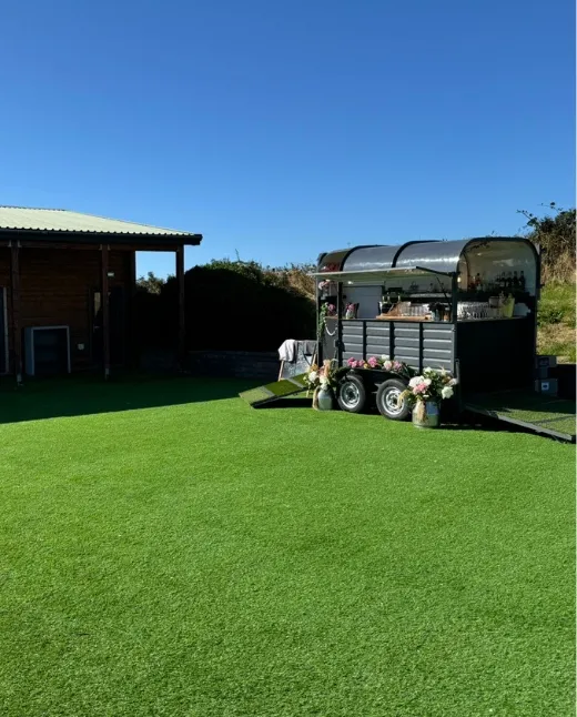 Outdoor wedding with hay bale seating and lake backdrop at Sunset Lakes