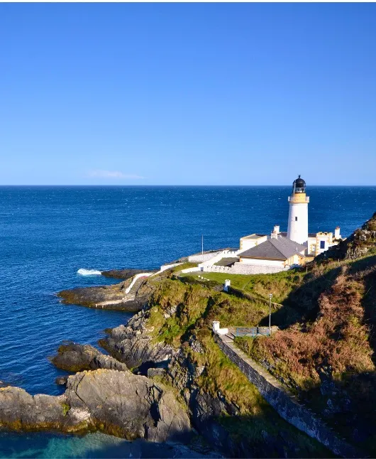 Historic lighthouse on rocky coastline of Isle of Man