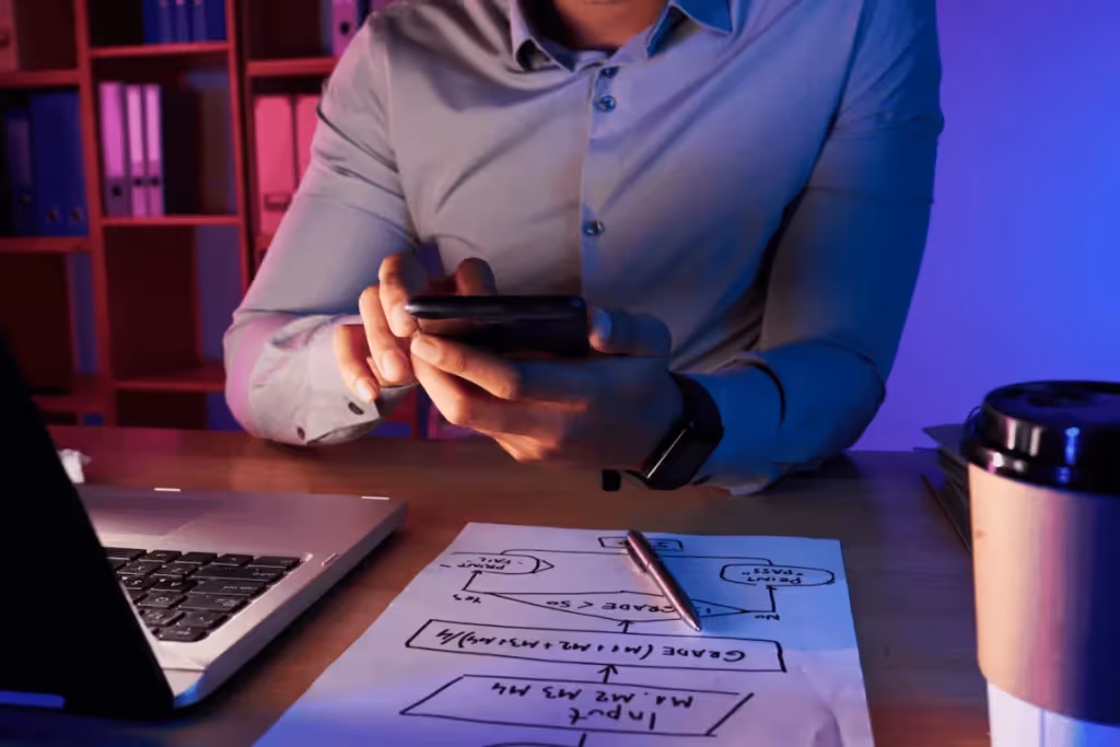 A person sitting at a desk with a laptop and a cup of coffee.