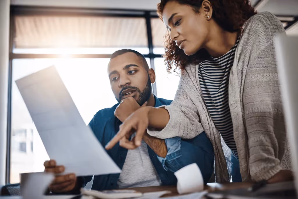 Two colleagues discussing a document in an office setting.