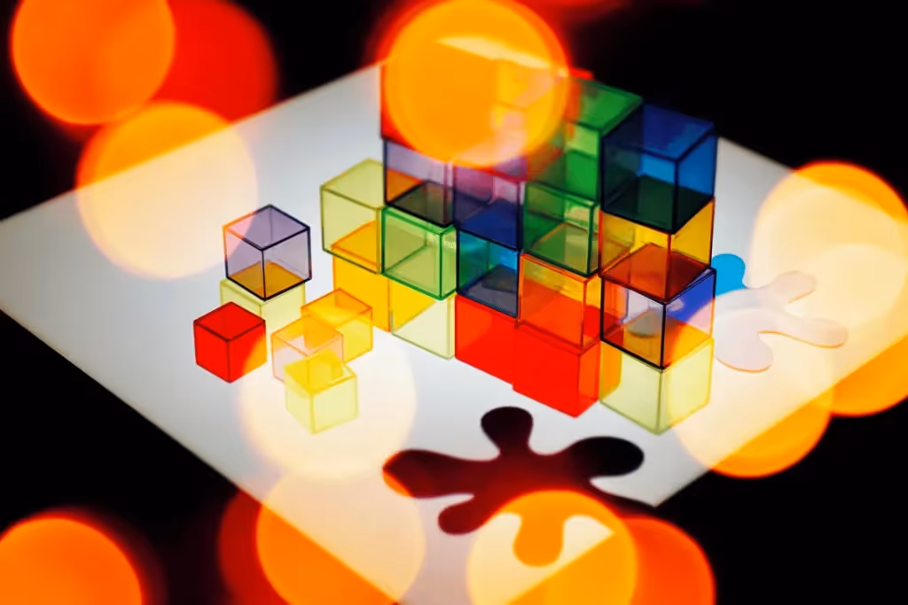 Vibrant 3D cubes stacked on a white surface with bokeh light effects.