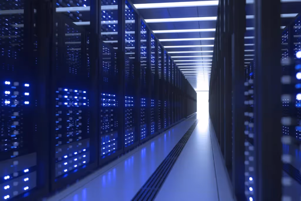 A corridor between rows of server racks with blue lights in a data center.