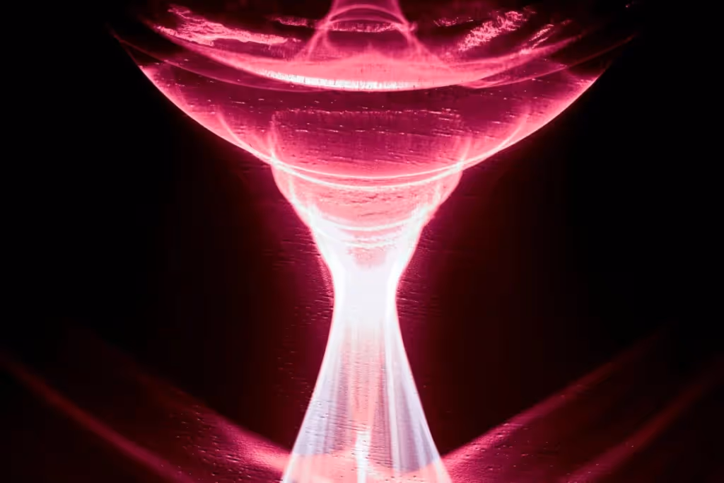 Dynamic pink vortex of light resembling a cascading hourglass effect.