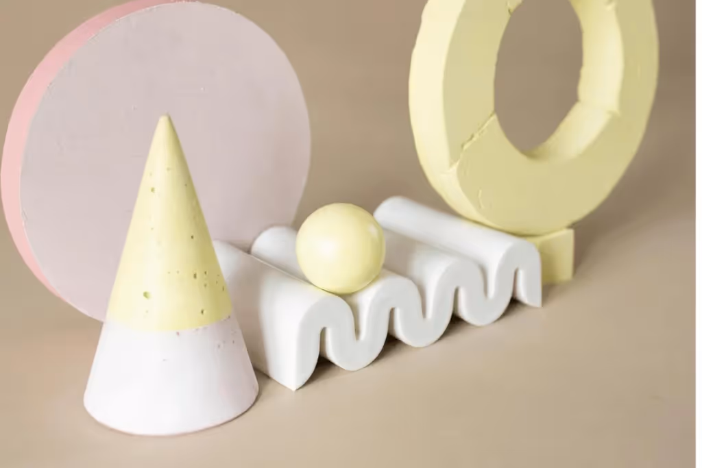 Minimalist geometric composition featuring a pink circle, yellow cone, and white wavy surface on a beige background.