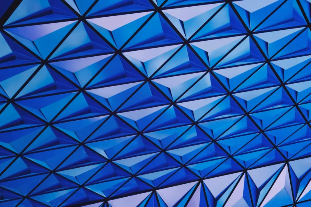 Abstract blue geometric pattern featuring a grid of 3D triangular prisms.