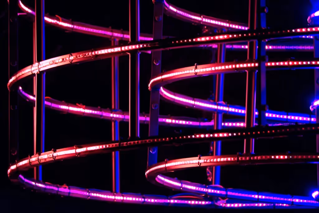 Abstract glowing lights forming a spiral pattern with pink and purple hues.