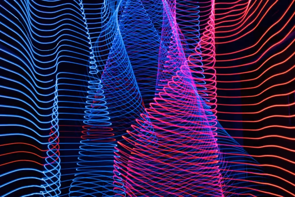 Curved blue and red neon lines forming a dynamic digital art pattern on black.