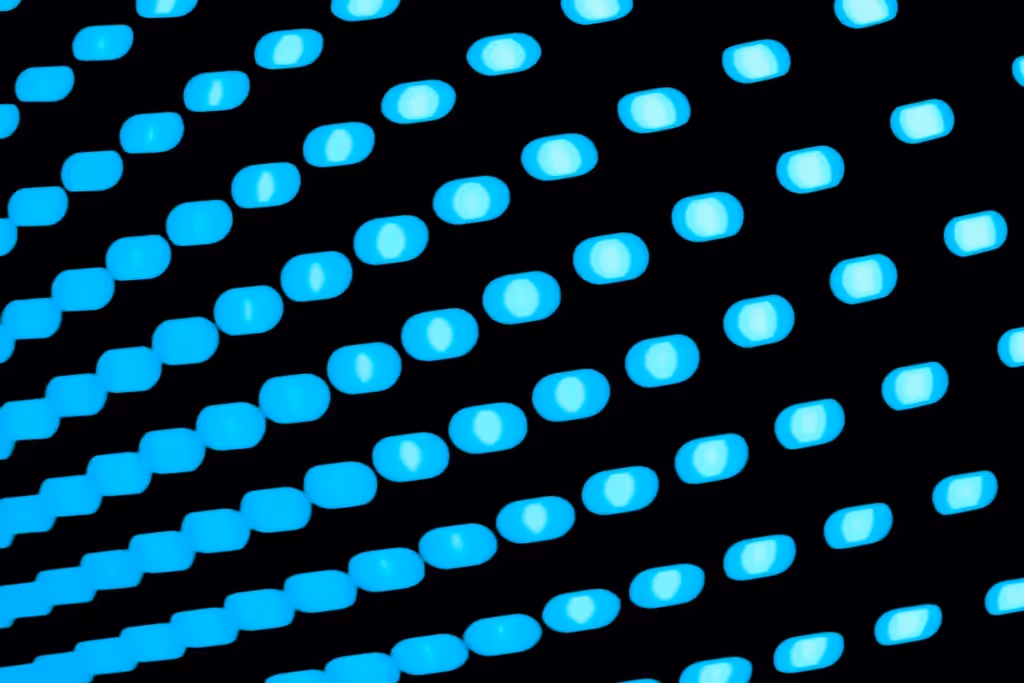 A close-up of a blue LED display with glowing light spots arranged in a diagonal pattern against a black background.