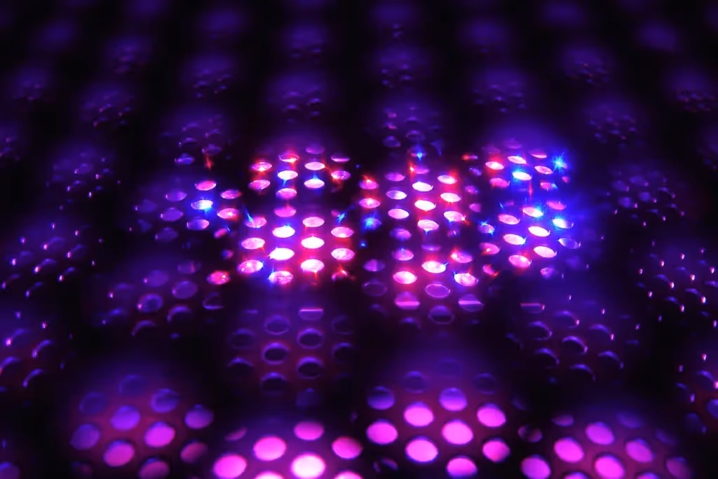 Abstract close-up of glowing purple and blue light dots on a dark surface