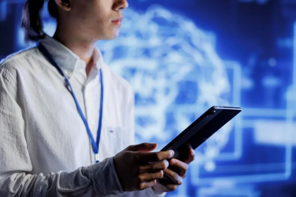 A person in a white shirt holding a tablet computer.