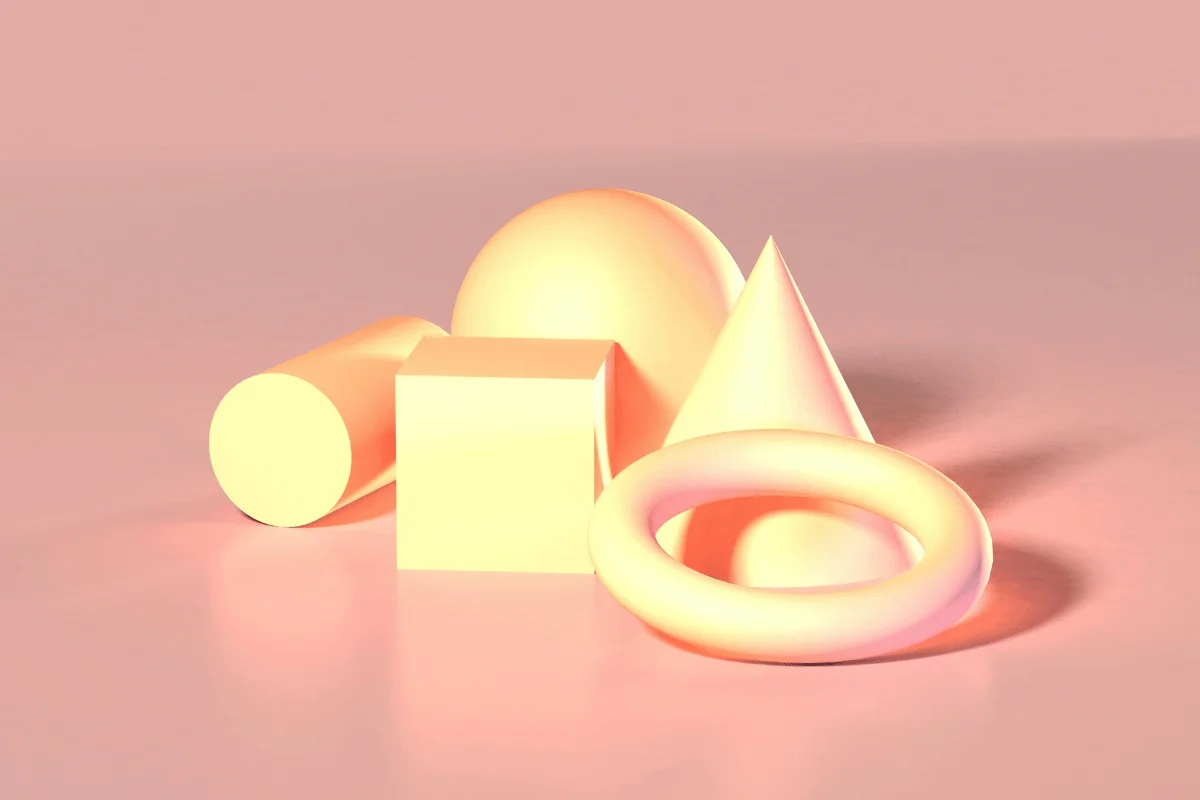 A collection of 3D geometric shapes—cylinder, cube, sphere, cone, and torus—are arranged on a smooth surface.