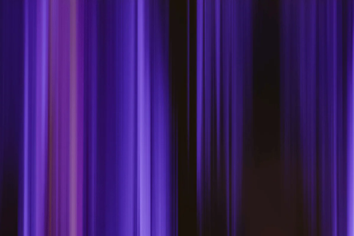 Abstract purple background with vertical light streaks and soft gradients in a smooth motion blur effect.