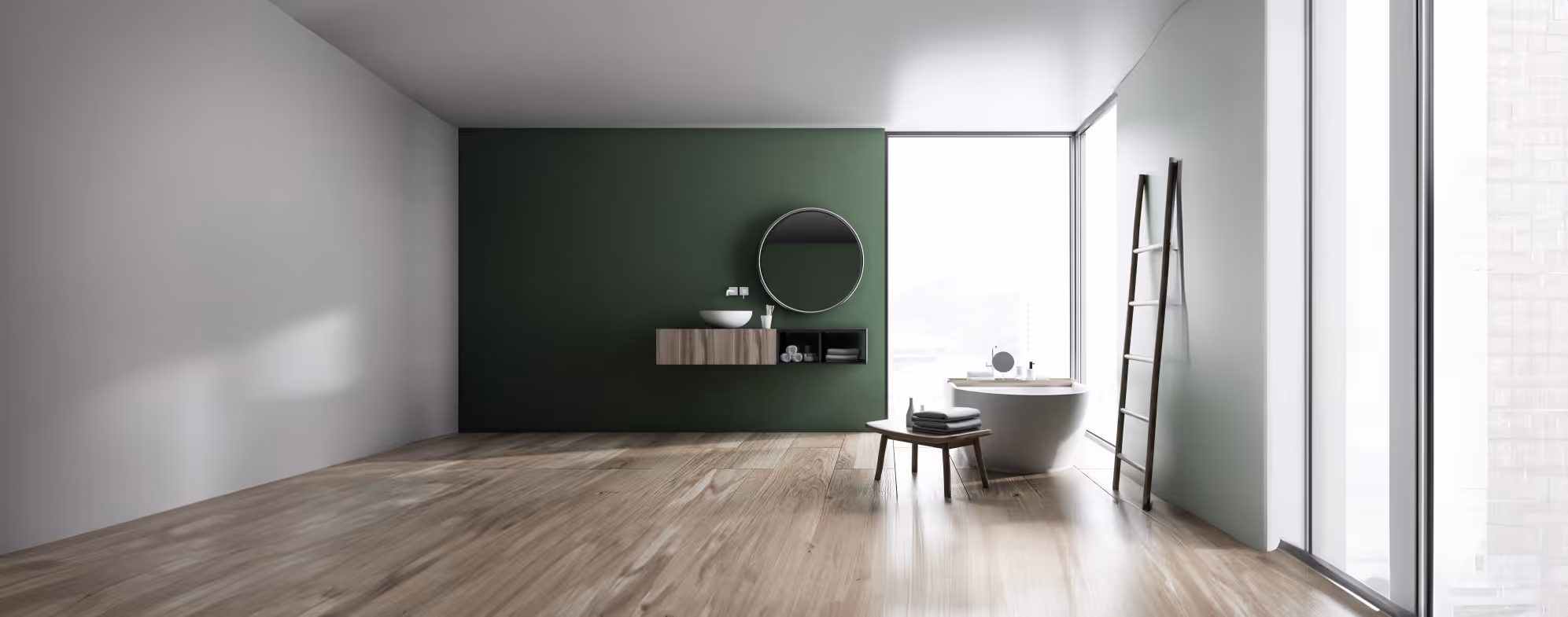 Nowoczesna łazienka z wolnostojącą wanną przy dużym oknie, zieloną ścianą z okrągłym lustrem i drewnianą podłogą.