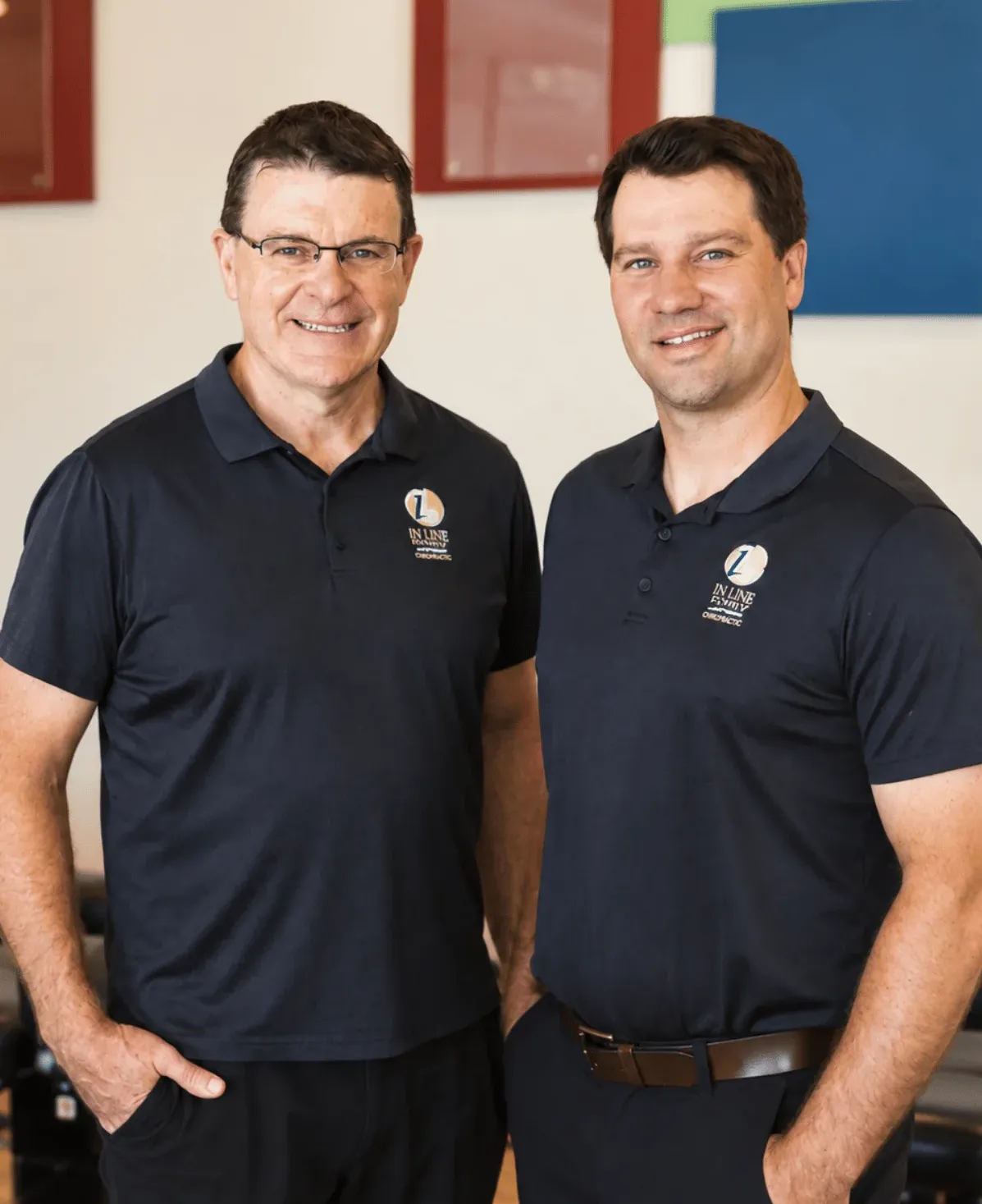 Dr. Glenn Lang and Dr. Adam Alexander, chiropractors at In Line Family Chiropractic, standing together in the clinic