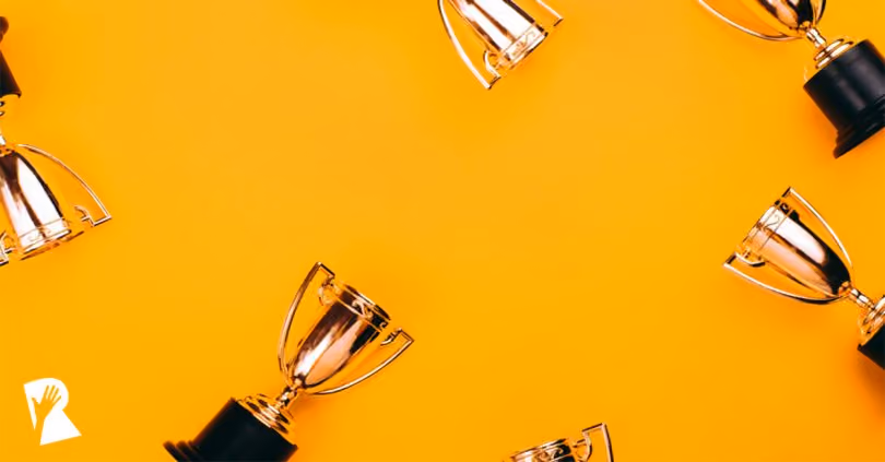 Gold trophies with black bases arranged around edges on an orange background.