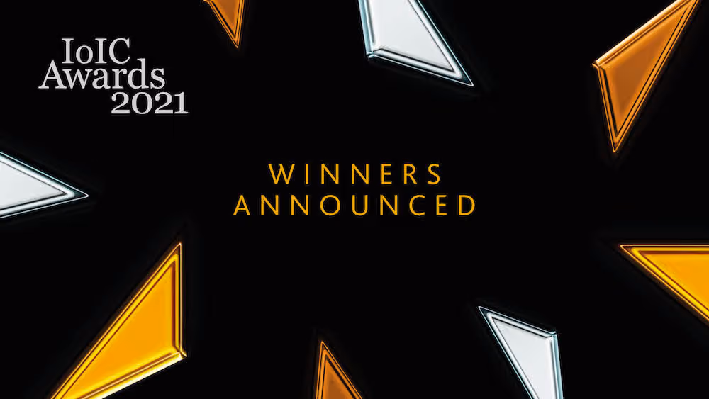 IoIC Awards 2021 winners announced text with stylized orange and white triangular shapes on black background.