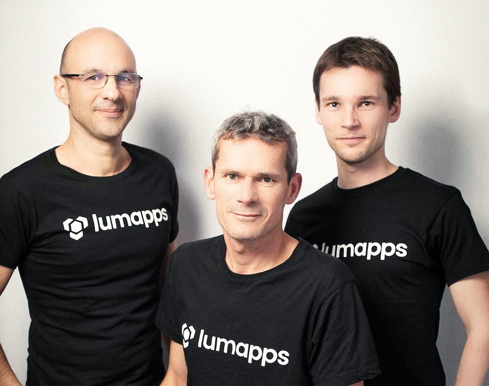 Three men wearing black Lumapps t-shirts posing against a plain white background.