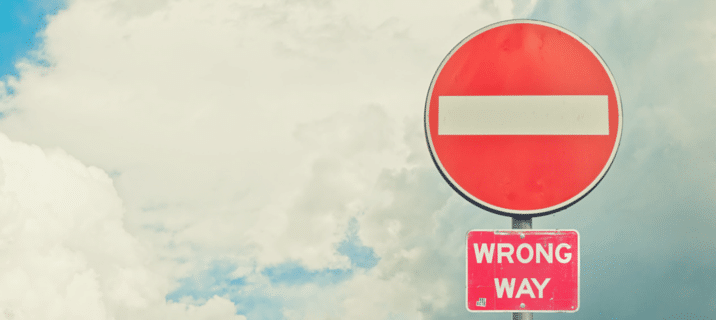 A "Do Not Enter" road sign with a red circle and white bar above a smaller "WRONG WAY" sign highlights the importance of clear messaging—much like using WhatsApp for business communication, set against a partly cloudy sky. Beekeeper