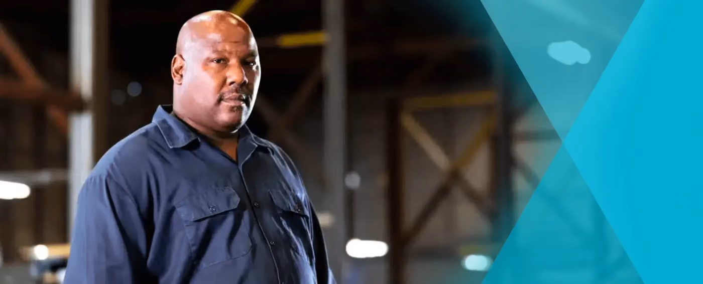 Confident man standing in a warehouse with blurred industrial background and blue design overlay.