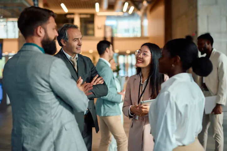 Group of colleagues having a conversation in a modern office lobby