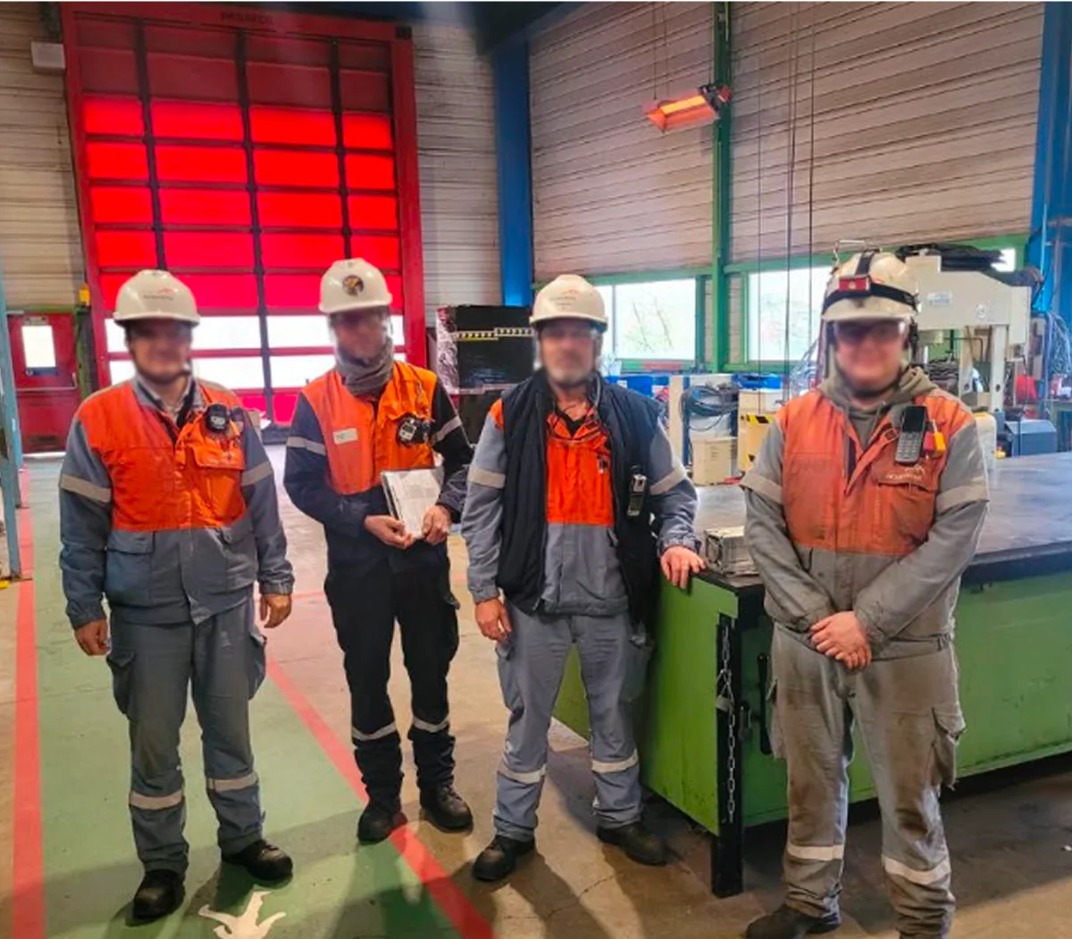 Quatre salariés d'ArcelorMittal France en tenue de travail dans un atelier du site