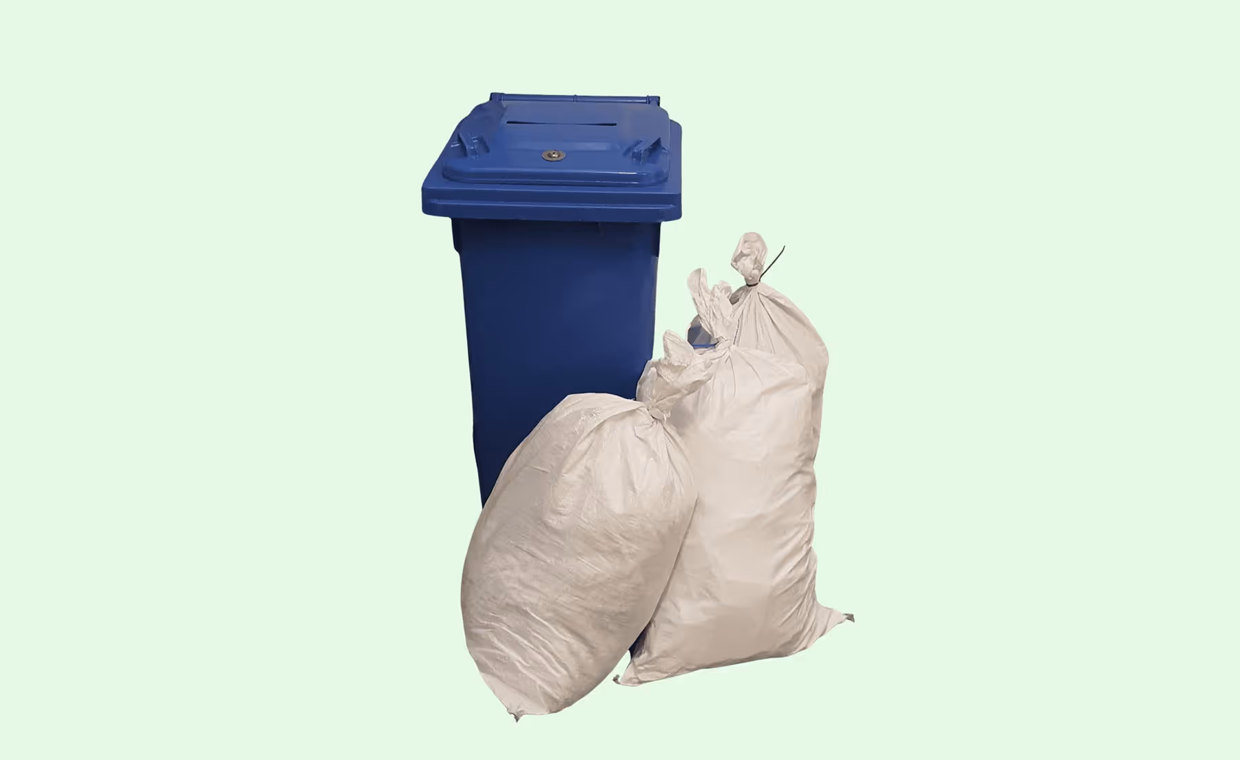 A blue trash bin with two large white garbage bags placed in front of it.