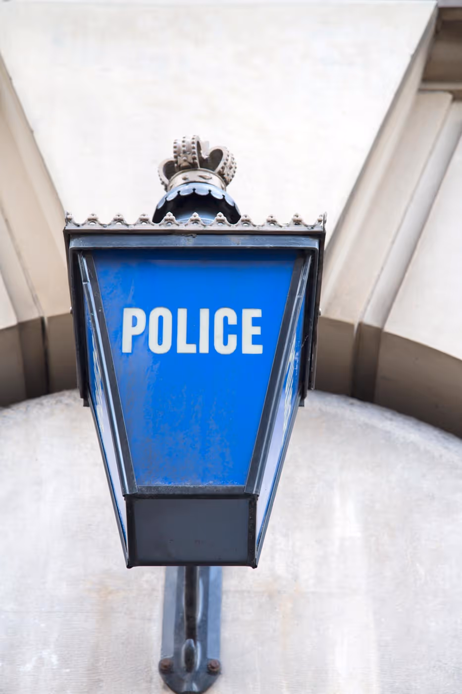 Blue police sign on a wall, with bold white lettering.