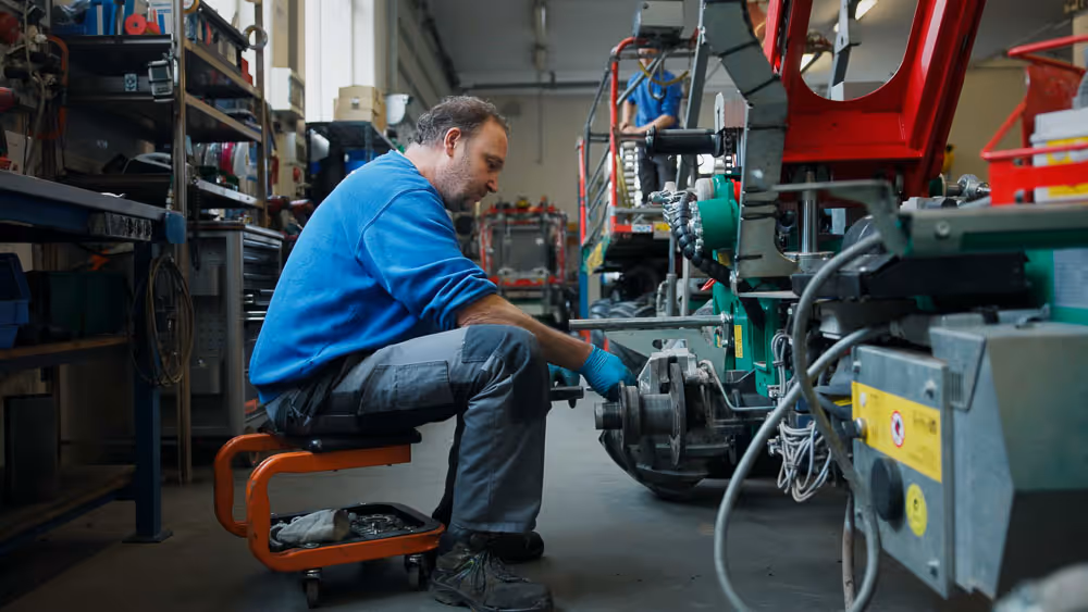 Servicemechaniker bei der Reperatur einer KNECHT Hebebühne und Erntemaschine
