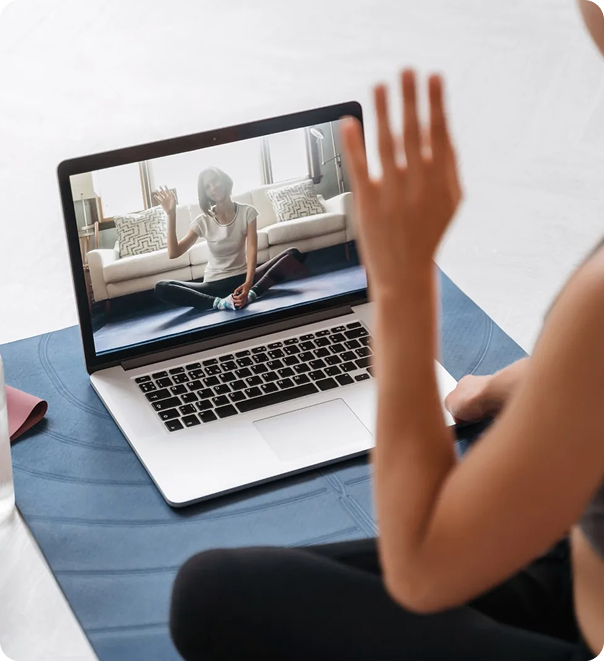 Person waving during a virtual coaching session on a laptop