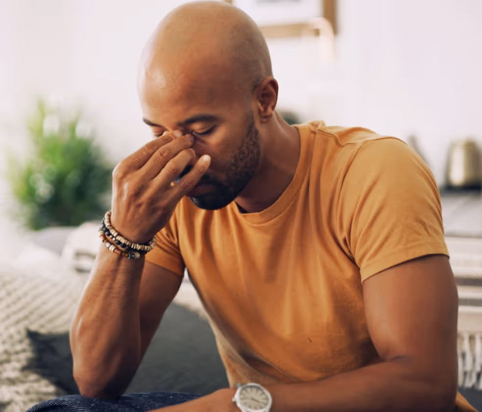 man holing nose experiencing sinus pain