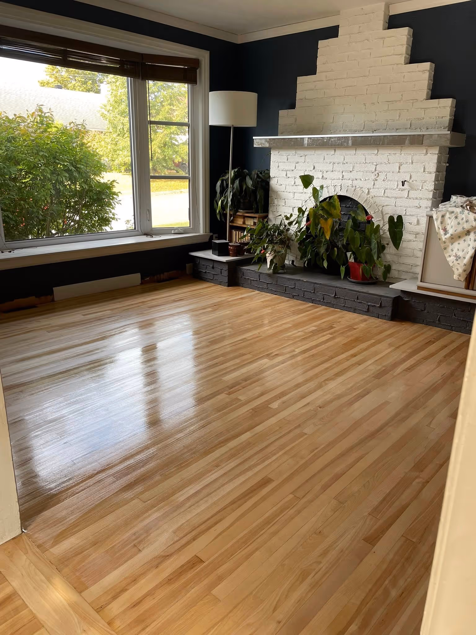 Plancher de bois franc sablé dans salon moderne avec foyer - finition naturelle