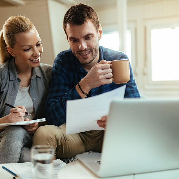 Couple reviewing documents and using a laptop to complete a secure digital lending and online loan application