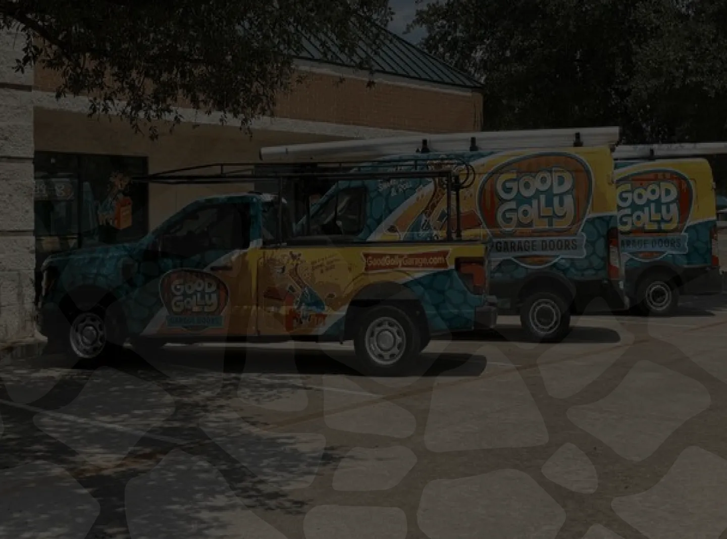 Three Good Golly Garage Doors company trucks parked outside a building.