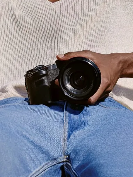 A man holding a camera in his lap.