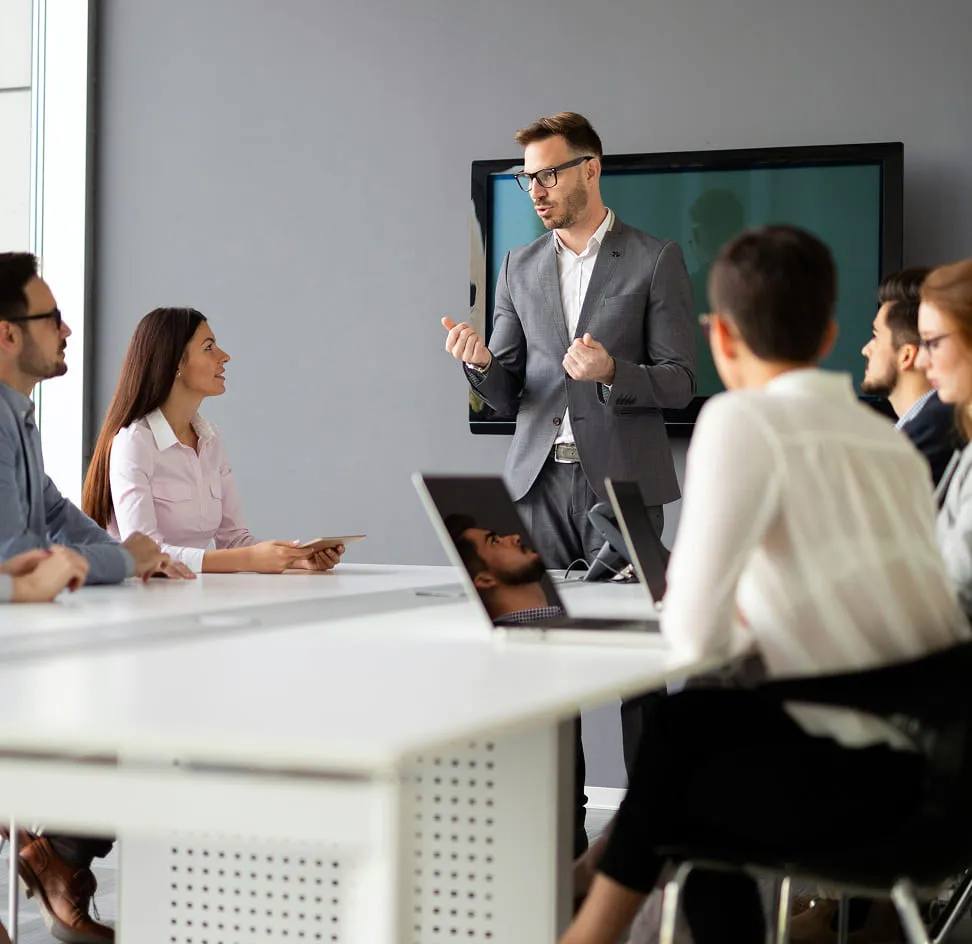 Leidinggevende spreekt met medewerkers tijdens teamoverleg