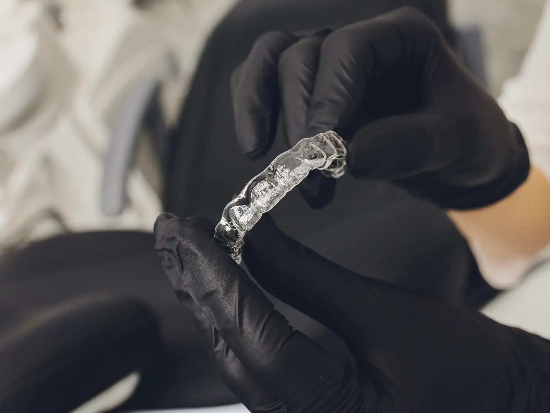 A group of smiling dental office staff wearing leis and sunglasses poses for a fun photo.