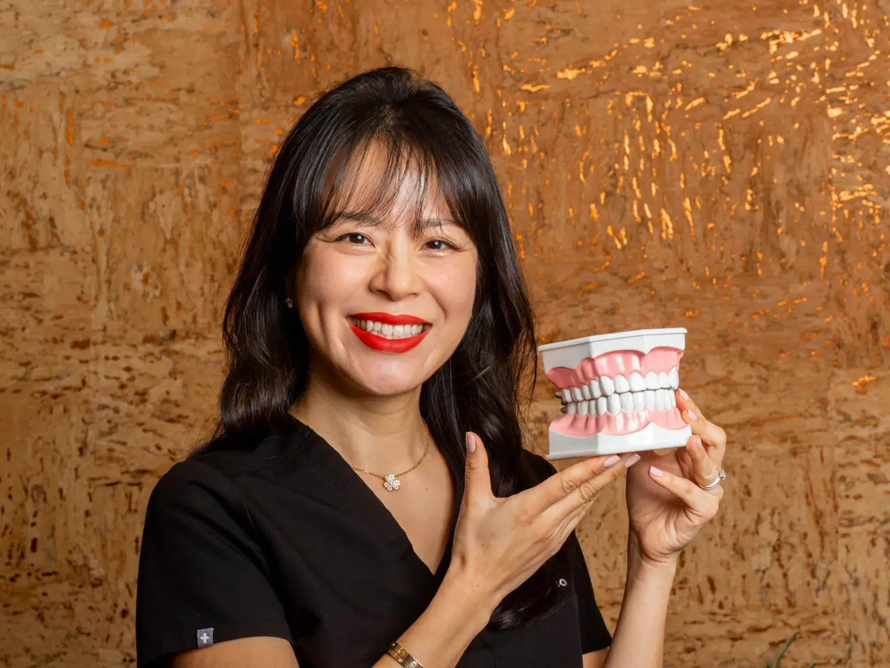 Three women smiling and holding matching purple mugs, standing side by side indoors.
