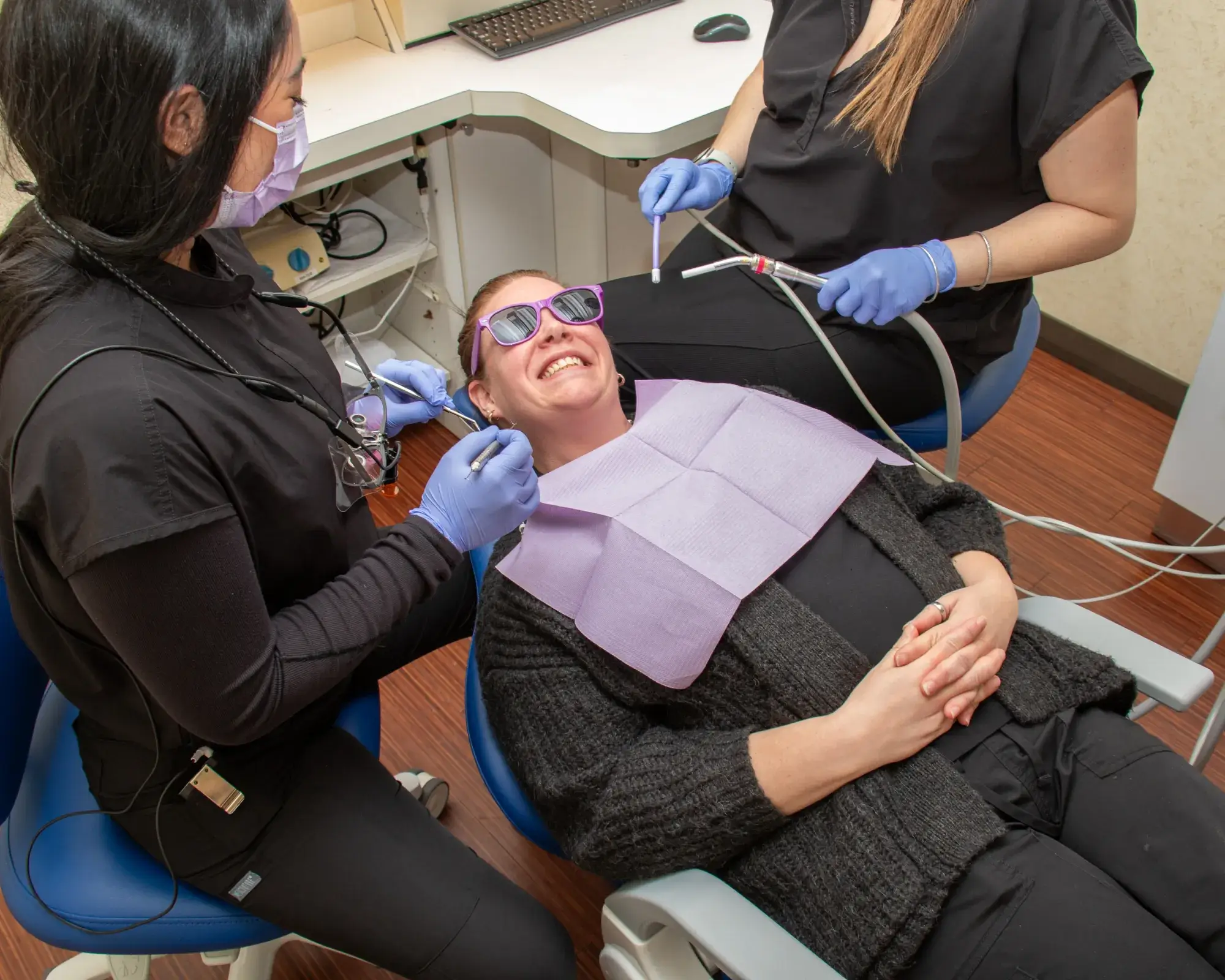 Two dental professionals look at a computer screen in a dental office.