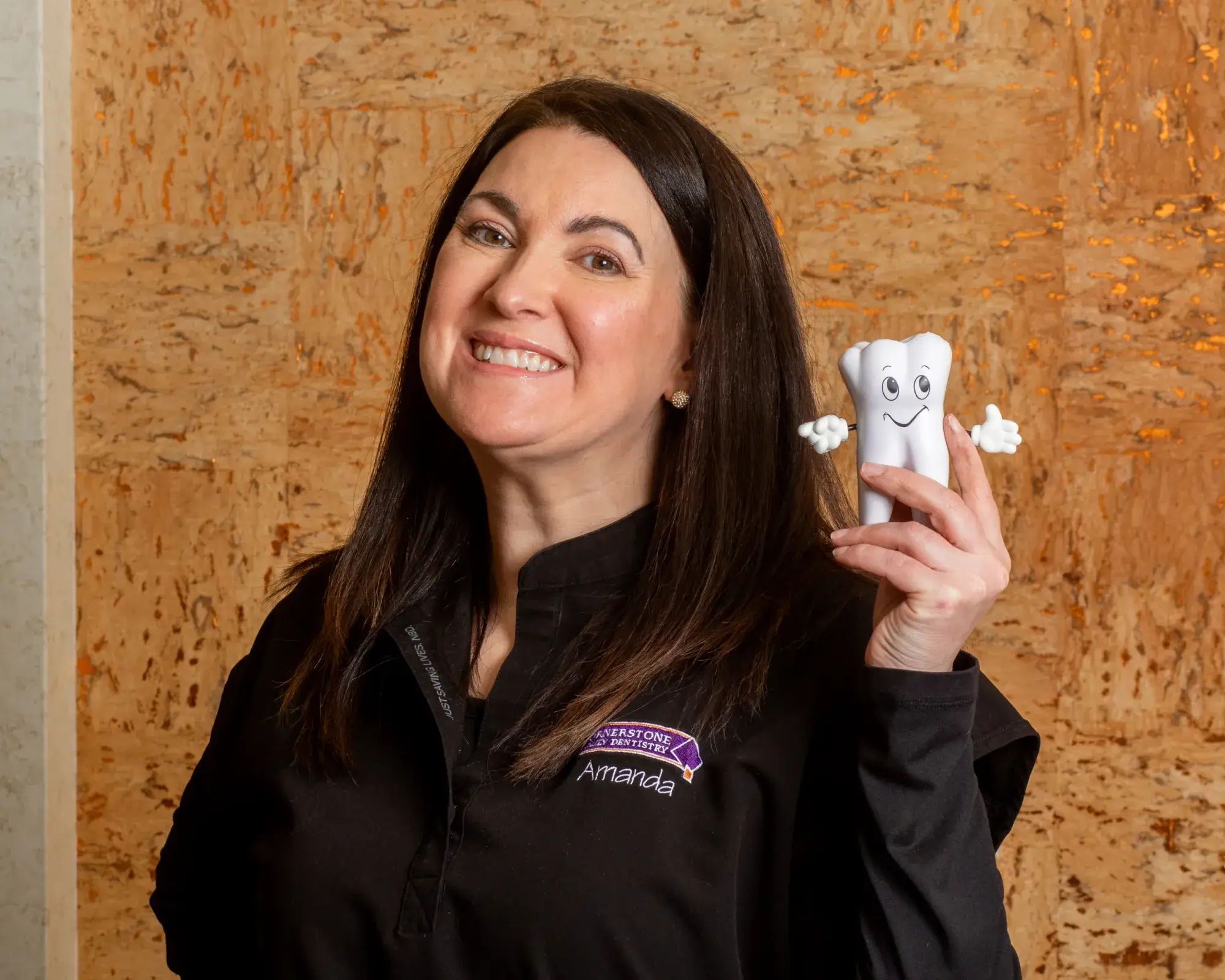 Dental chair with attached tools and a mounted screen in a bright examination room.