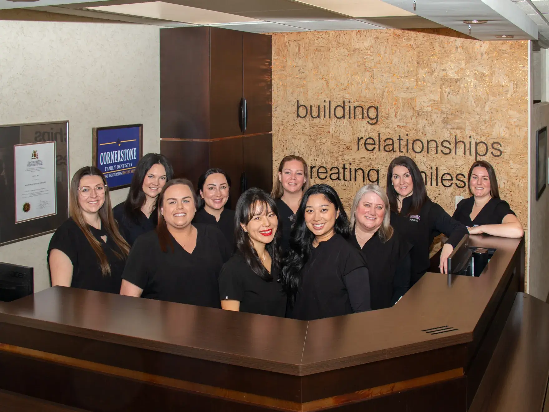 A woman helps a child use a tablet while sitting on a couch together.