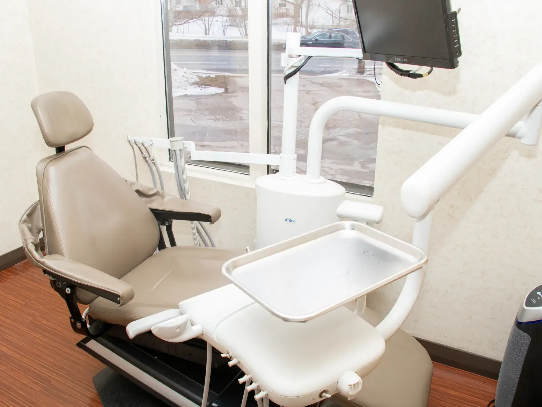 A woman smiling while talking on a phone at an office desk.