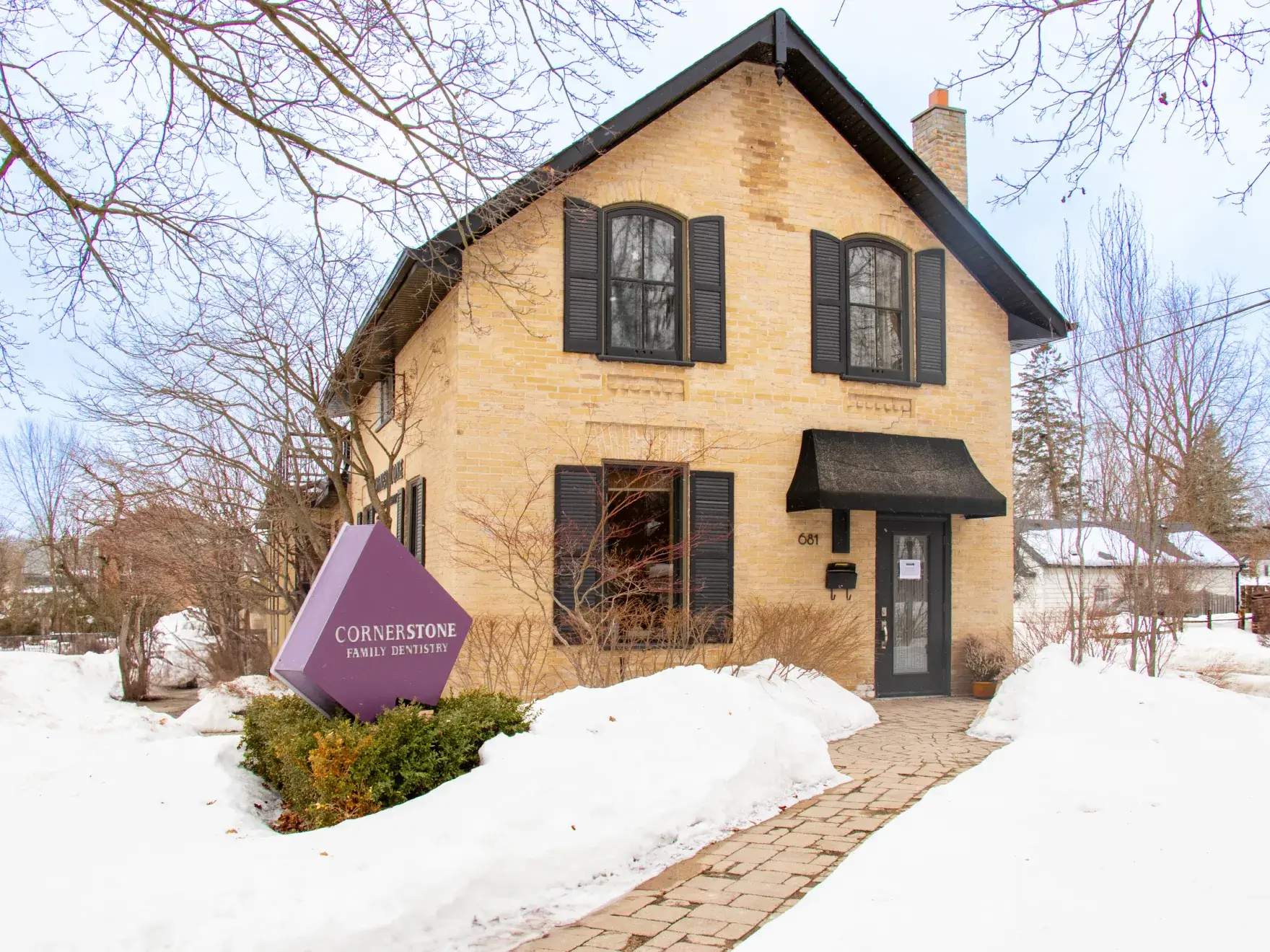 A dental office with an empty reclining dental chair and dental equipment nearby.