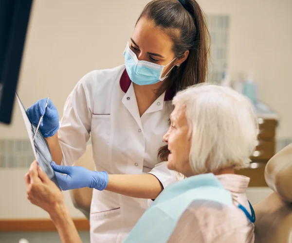 A woman in a dentist's chair with a patient.