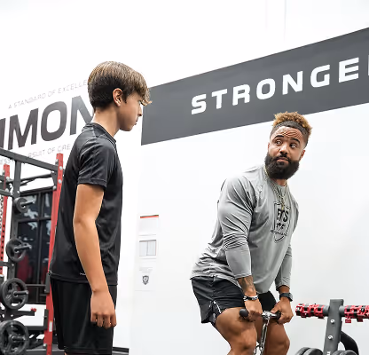 Coach instructing athlete during strength and conditioning session