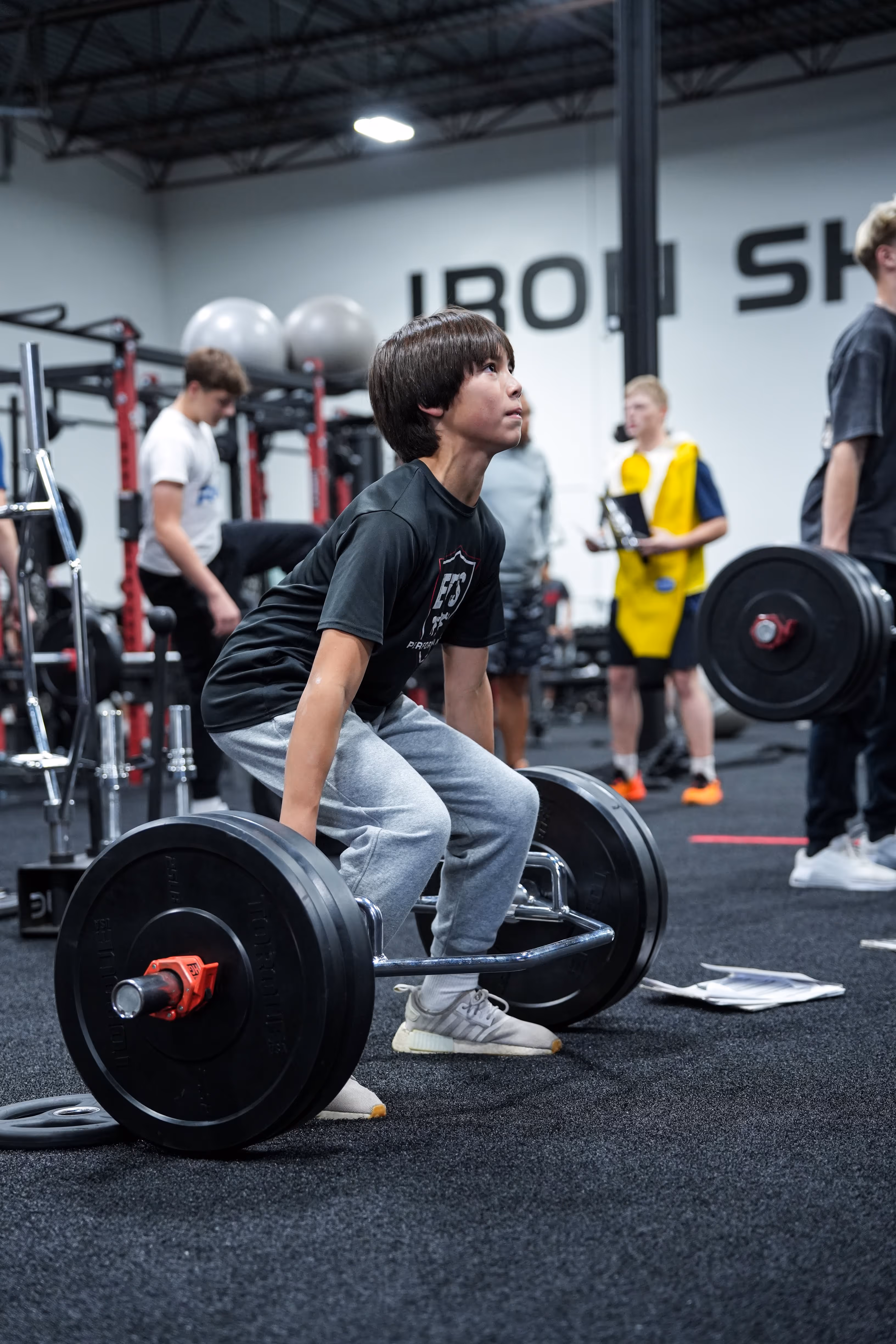 Youth athlete performing barbell strength training at ETS Performance