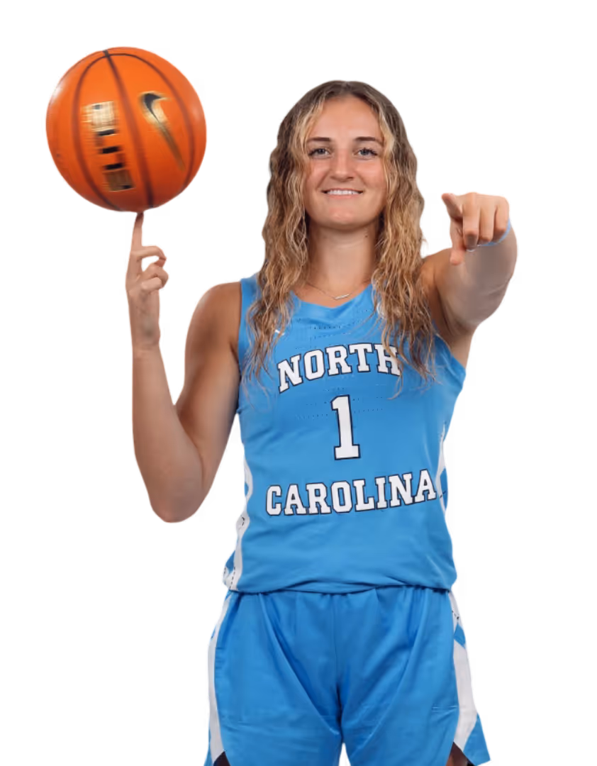 Basketball player in blue jersey holding a basketball and raising one arm in celebration